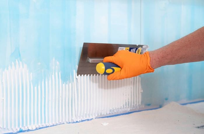 Apply the adhesive using a notched trowel