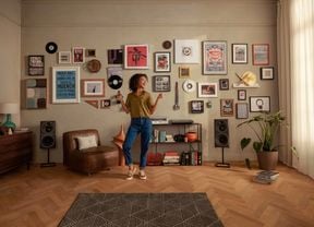 Living room with lady dancing in front of a wall filled with hanging pictures