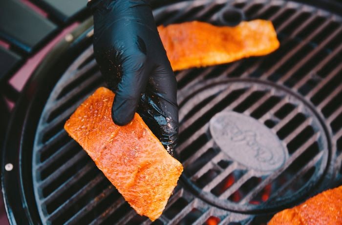 Person holding a fillet of salmon coated in spices