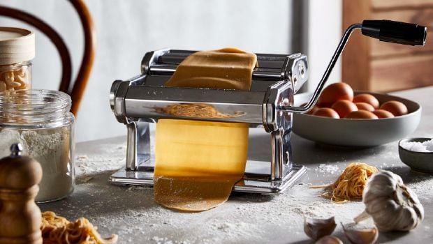 a kitchen appliance rolling out pasta dough
