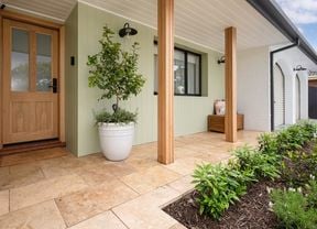 Image of a house with a paved tile pathway leading up to the front entrance. 