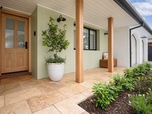 Image of a house with a paved tile pathway leading up to the front entrance. 