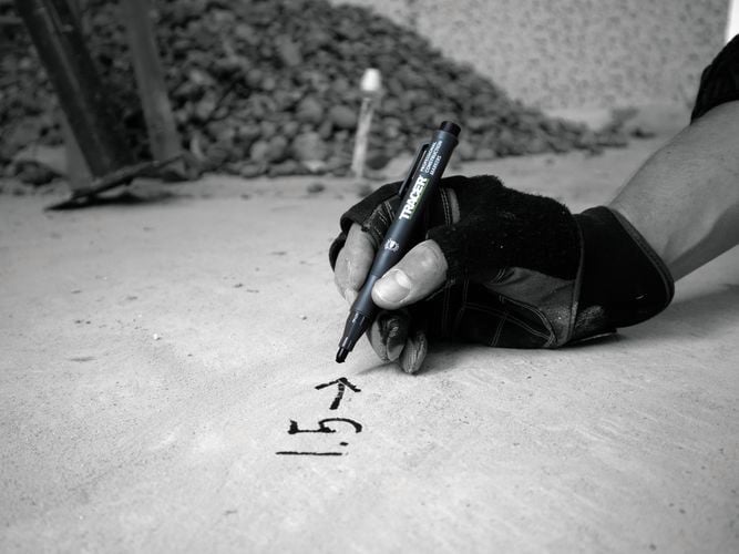 Writing
  using the Black Tracer Clog Free Marker through dust on concrete