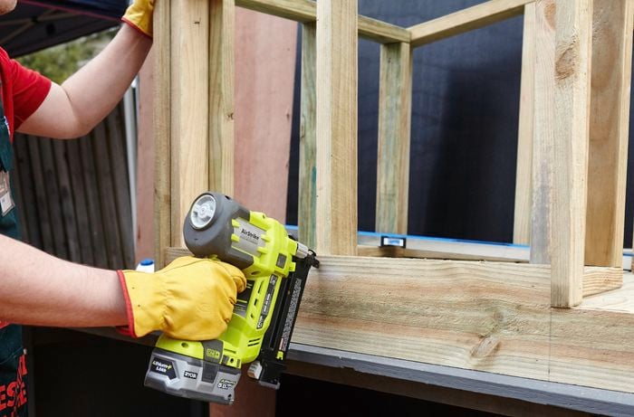 Person drilling timber frame pieces together.