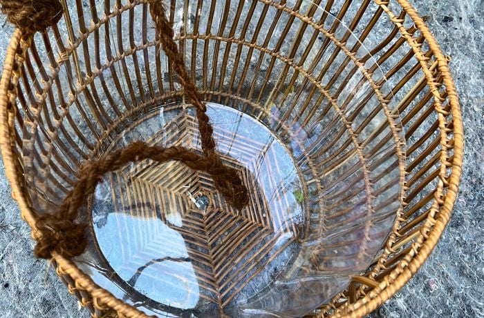 Rope attached to a rattan woven basket to create handles