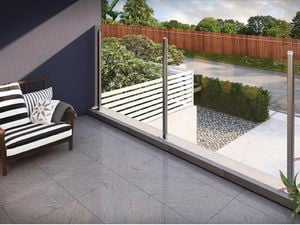 An indoor tiled area with installed drainage system, overlooking a driveway