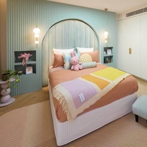 Pastel bedroom featuring a pale blue feature wall with recessed bedside tables and a double bed with pastel linen in orange, purple and yellow. 