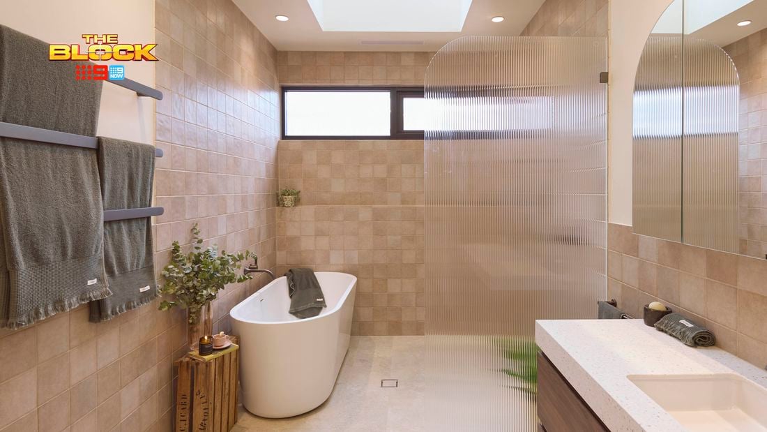 Natural coloured brown bathroom with timber vanity, white marble benchtop, curved shower screen and bath