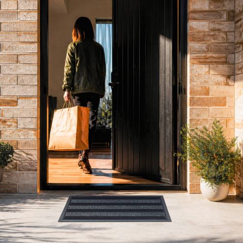 Door mat with stiff rubber bristles helps scrape off mud and poly grass fibres soak up moisture at the door.