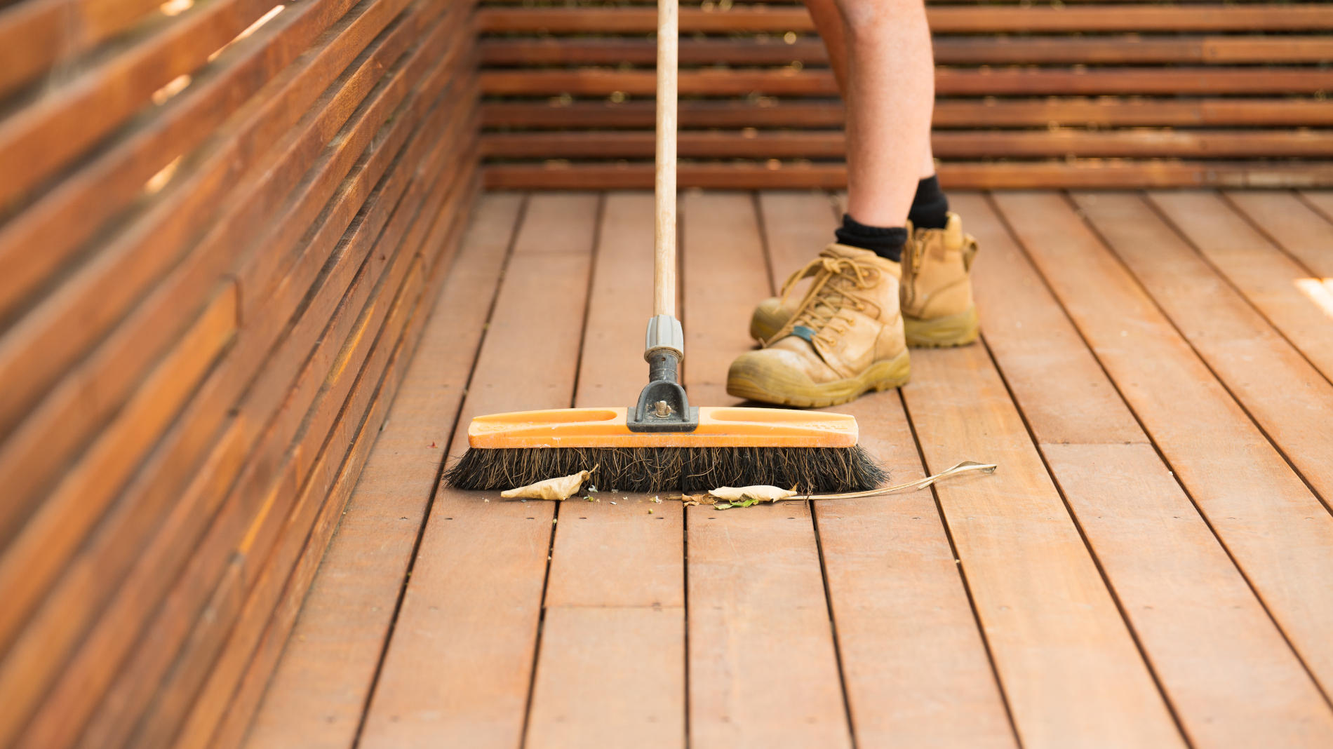 Person sweeping a deck