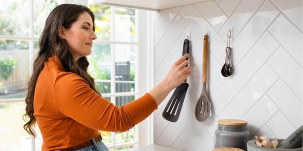 woman organising utensils in a kitchen