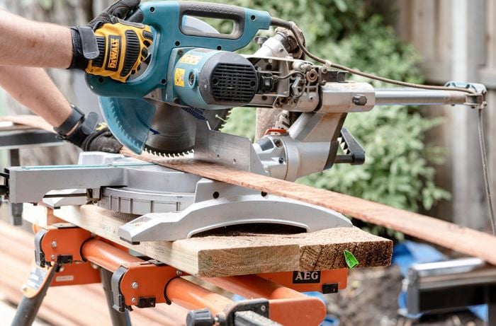 Person cutting timber edging with a circular saw.