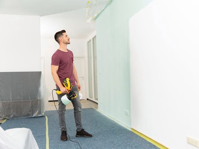 Wagner Flexio W590 with i-Spray attachment to spray teal onto a wall.
