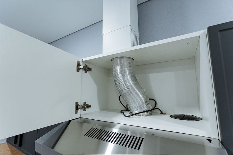 Semi-rigid aluminium ducting connected to a kitchen rangehood.