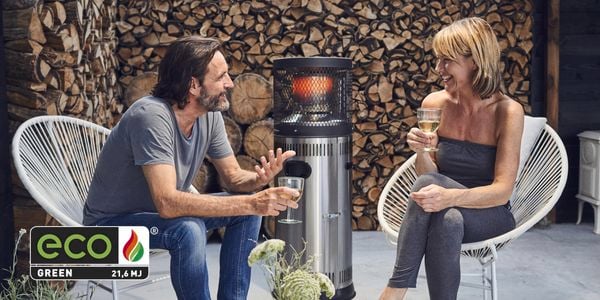 People are standing around the heater having a laugh
