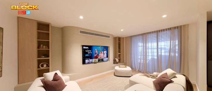 Contemporary living room featuring curved cream sofas, a wall-mounted TV, built-in timber shelving and floor-to-ceiling sheer curtains.