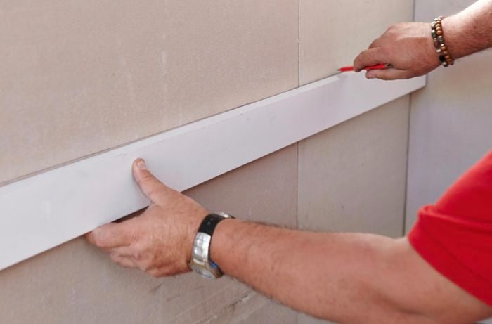 A wall being marked with a pencil by a Bunnings team member