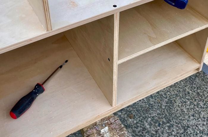 A DIY camp kitchen box with panels of wood attached to create shelves