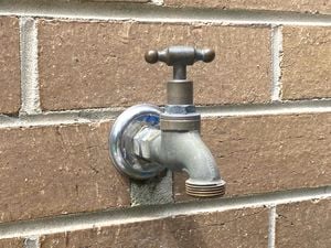 brass garden tap fixed to a brown brick wall