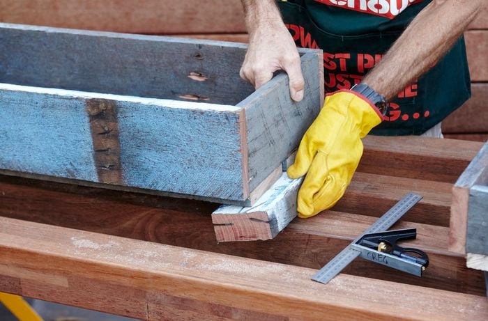 Feet being attached to the bottom tier of a herb planter by a Bunnings team member