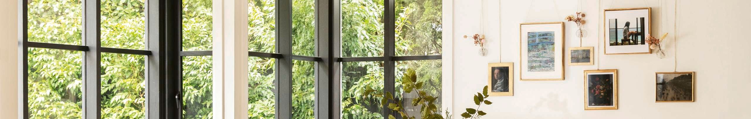 Windows looking out at greenery and wall prints.