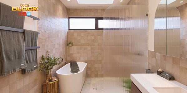 Natural coloured brown bathroom with timber vanity, white marble benchtop, curved shower screen and bath