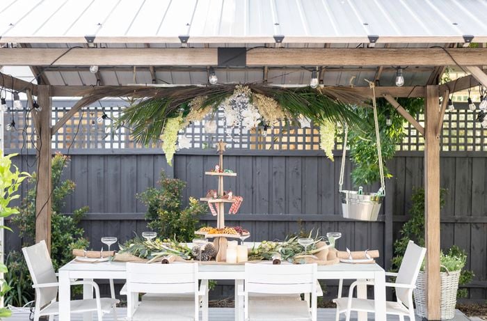 Gazebo with a floral chandelier and table with platters of food.