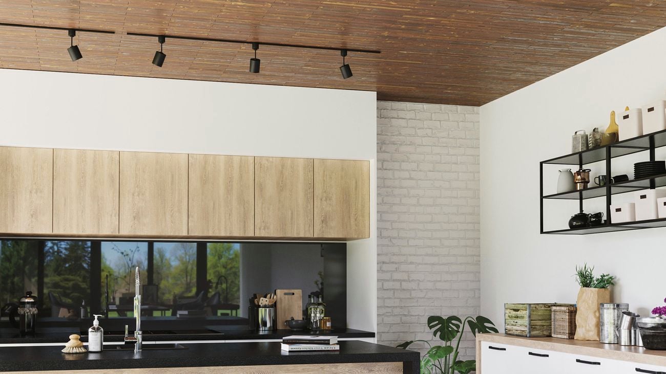 Kitchen with concrete floors, timber cabinets and black benchtop.
