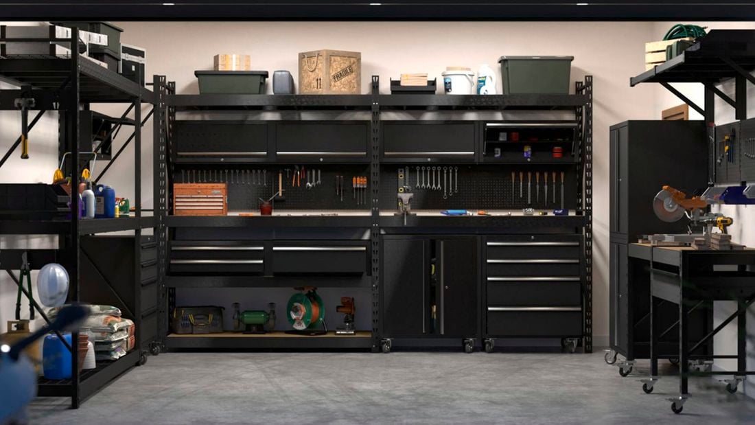 A garage space featuring Rack It storage solutions against the wall and on both sides, featuring shelves, pegboards and drawer units