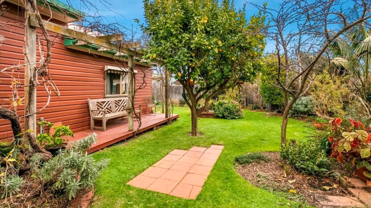 Exterior of house with deck and garden, before being renovated.