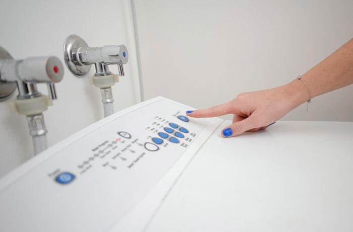 Closing the lid and running the washing the washing machine.