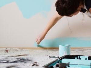 Painting a wall with blue paint