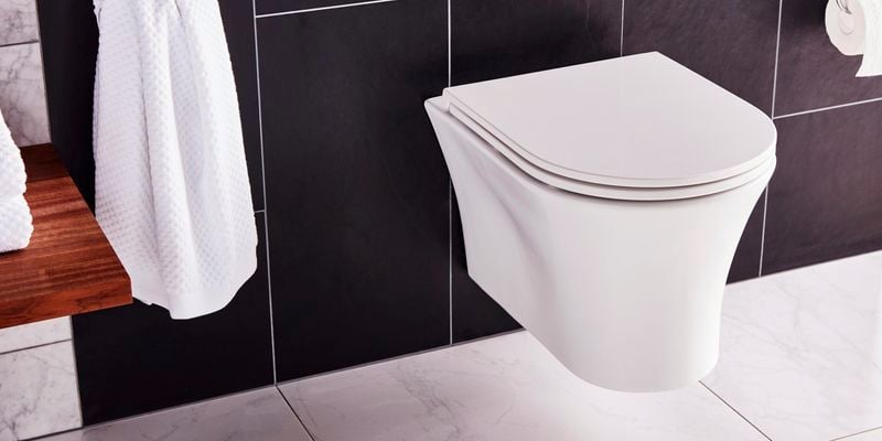 bathroom with black tiles and white toilet