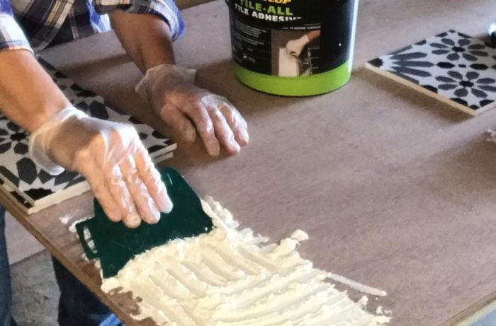 Tile adhesive is spread onto a tabletop