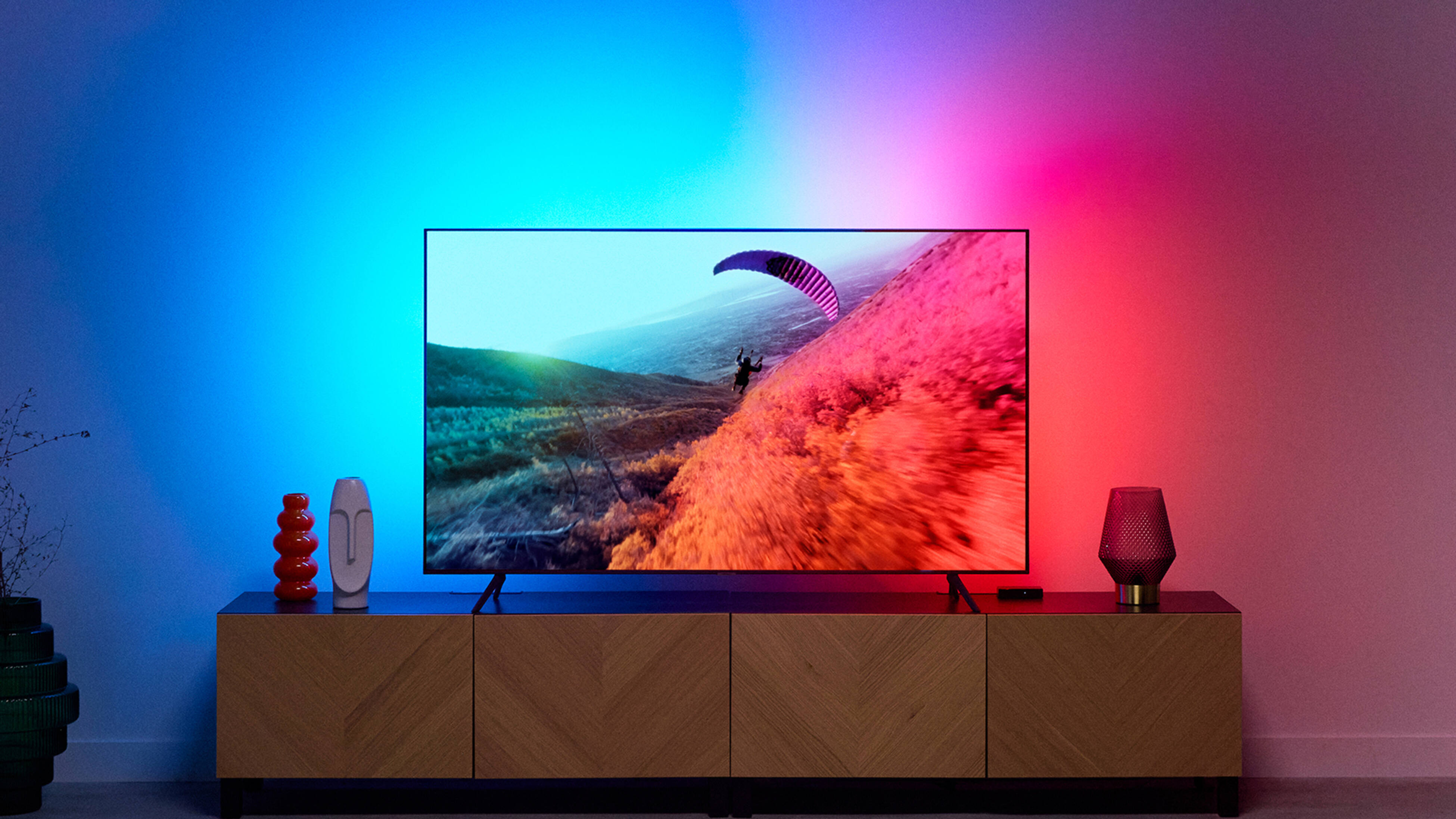 tv on a stand with multicolour LED lights in the background
