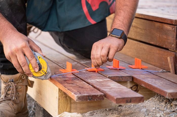 Wedges being added between laid boards to ensure even spacing