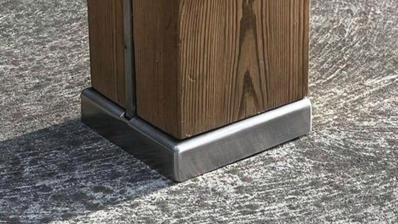 Four bolts form a square on a pillar of wood 