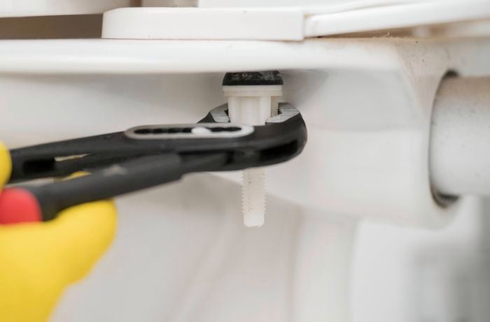 Use pliers to remove the old toilet seat 