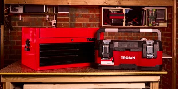 Red Trojan toolboxes in front of red bricks