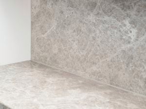 Finished silicone seal neatly applied along the joint between a stone-look benchtop and matching splashback, creating a clean, continuous finish in the corner of the installation.