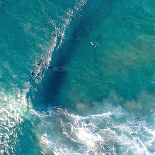 Birds eye view of the ocean with a wave