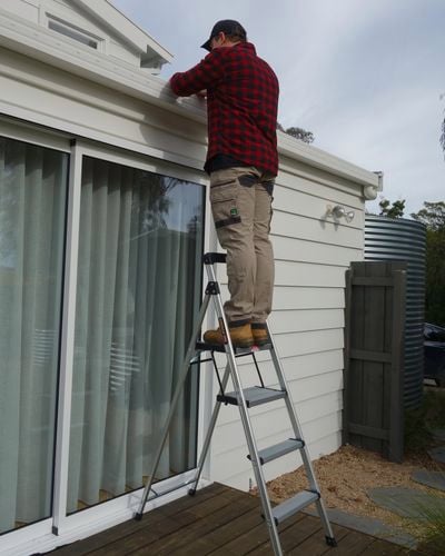 tradesperson working on a ladder
