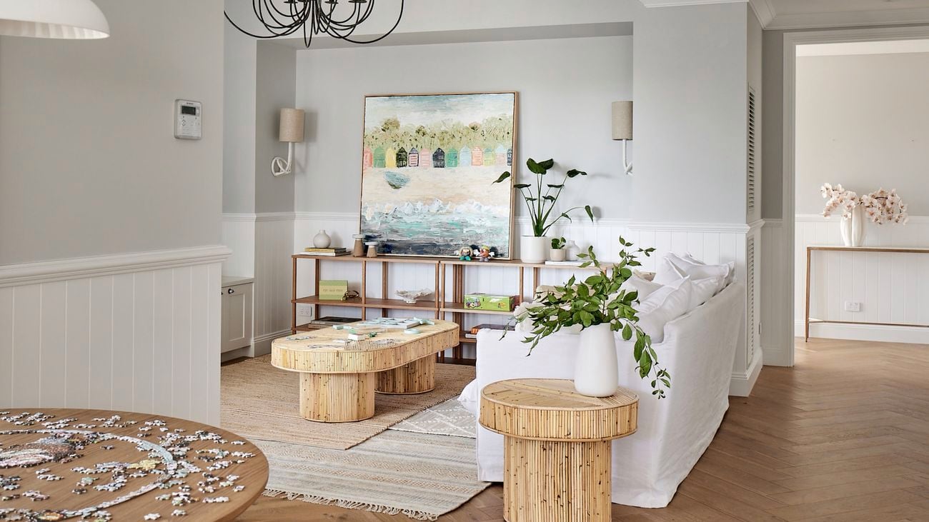 Shot of a living room with black hanging lights and hardwood floors.