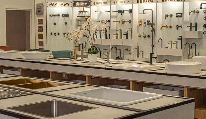 A kitchen display area with sinks and tapware in it.