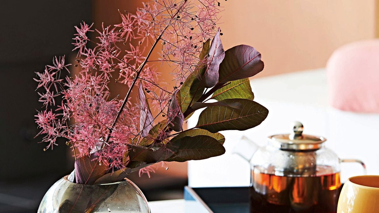 Marble coffee table adorned with cosy toned accessories and florals