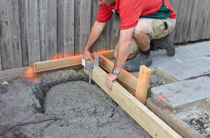 Person filling hole with concrete.