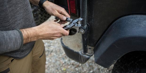 A person holding a dual force multi tool with his hands.