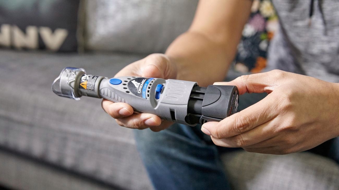 A person holding a Dremel 7020 Pet Grooming nail trimmer