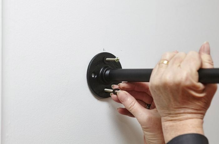 A person inserting screws into shelf support flanges