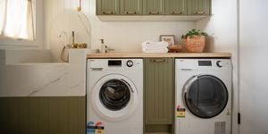 A modern laundry room featuring a front-loading washing machine and a matching dryer placed side-by-side.
